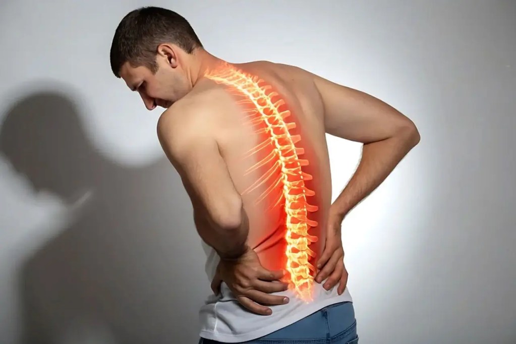 Man touching his lower back in pain with a glowing red spine illustration along his back to show back pain.